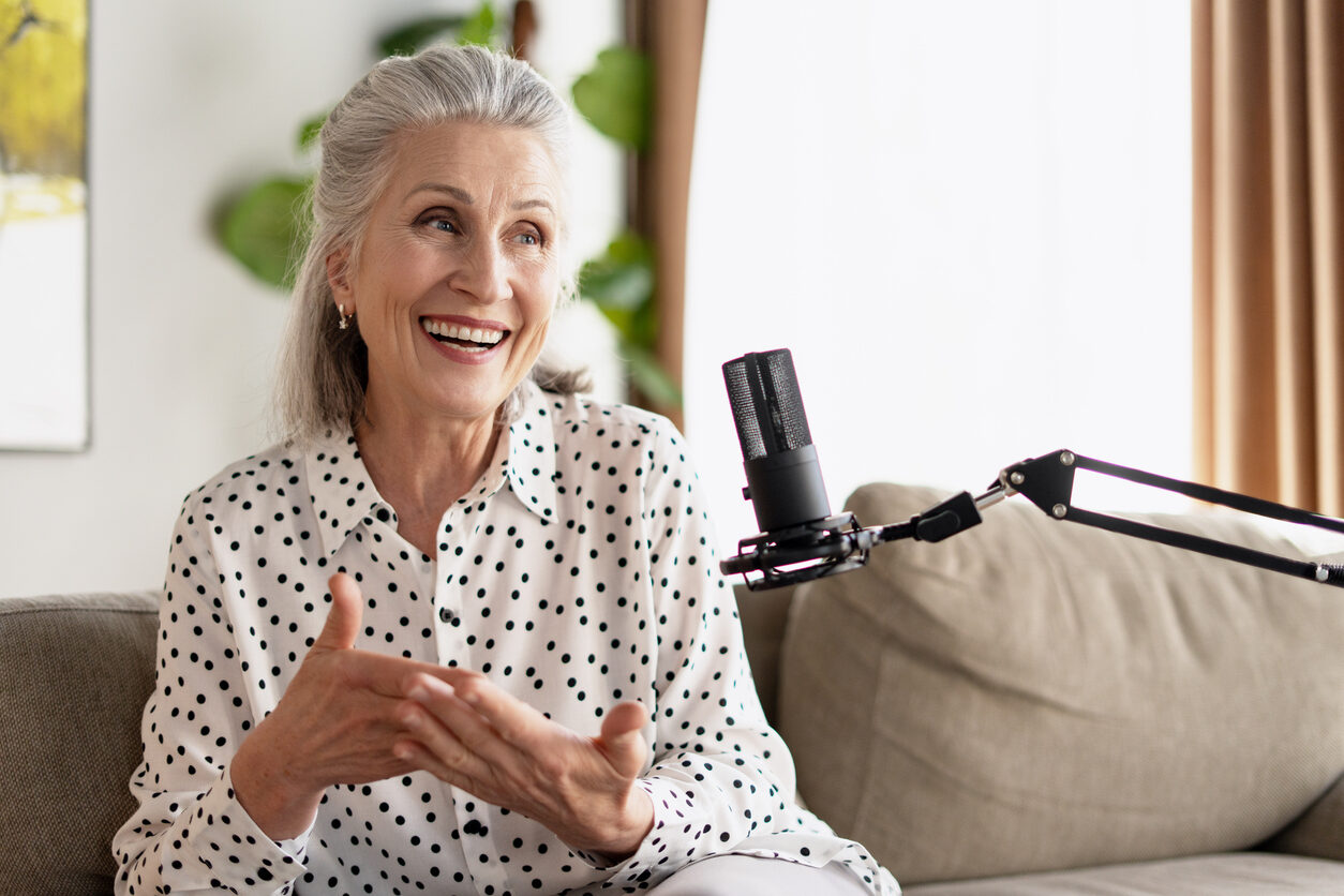 Senior woman recording a podcast from her home studio